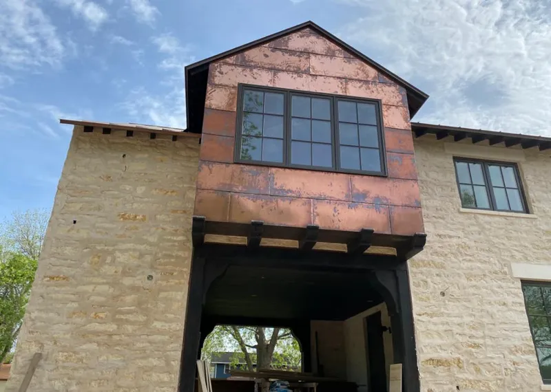 Copper metal panel facade on a stone building for Skylight Installation in Travis Ranch